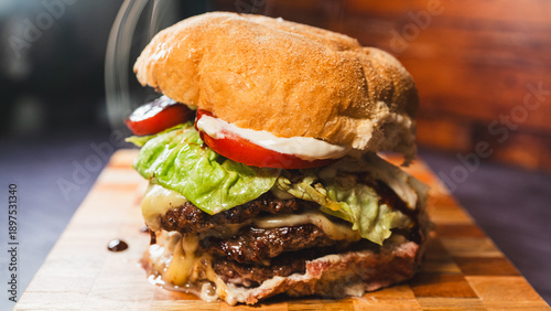 Photos Massive messy triple patty burger overflowing with melted cheese, fresh lettuce, tomato, and special sauces