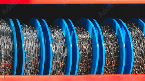 Canvas Print Spools of various metal chains lie in row on display case of  specialty store