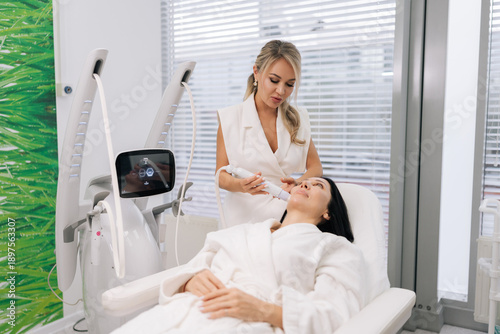 Photography Vertical shot of cosmetologist female performing microneedling anti-aging skincare treatment on woman face in modern beauty clinic, promoting rejuvenation