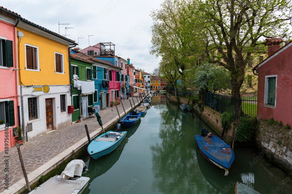 Obraz premium Colorful houses along canal with boats in Burano island, Venice Italy