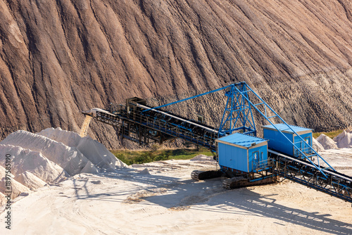 Photography Industrial mining conveyor system transports mineral material potash dump sunlight day