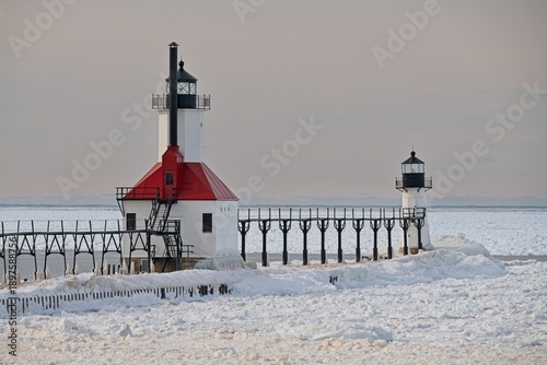 Lighthouse on icy pier in winter on Lake Michigan