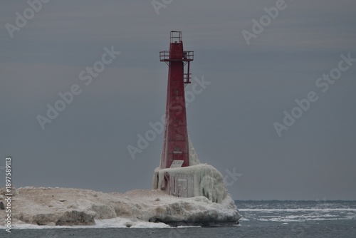 Winter lighthouse on snowy beach