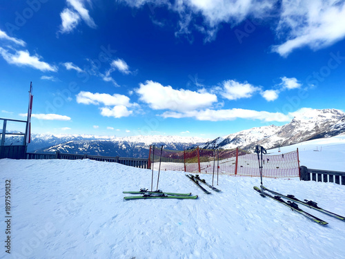 View in the Alps on a ski summit.  Skis lined up in the snow.