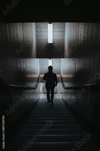 Person Walking Down Stairs in a Dimly Lit Corridor at Night