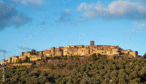 Panoramic view of Gavorrano, a medieval hilltop village in Maremma, Tuscany, illuminated by the warm light of sunset