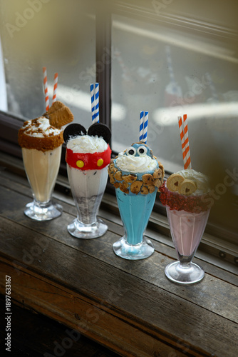Fényképezés Four different types of milkshakes with different toppings and straws