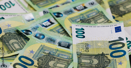 Schilderij op canvas Close-up view of scattered 100 euro banknotes on a flat surface, showcasing intr