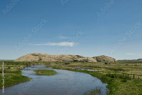 Foto Granite Rock Outcrop Rising Beside a Winding River