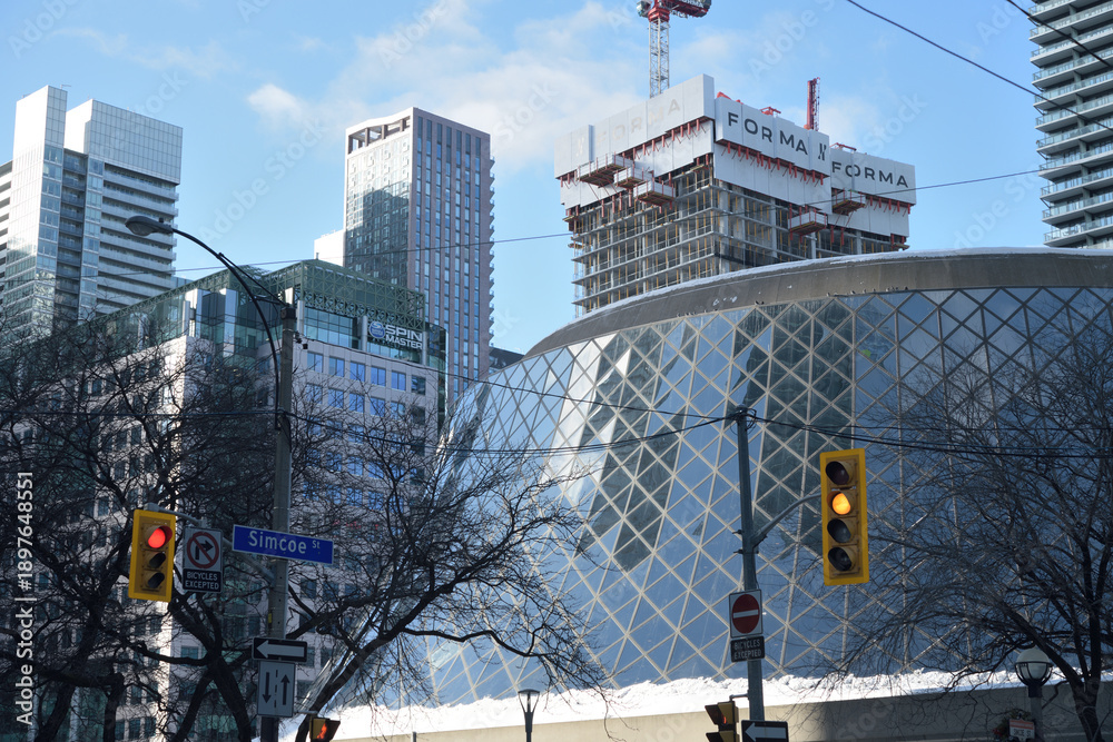 Fototapeta premium Roy Thomson hall, a concert venue, designed by Arthur Erickson, 1982, with FORMA Condos under construction, looking northwest on Simcoe St, Toronto