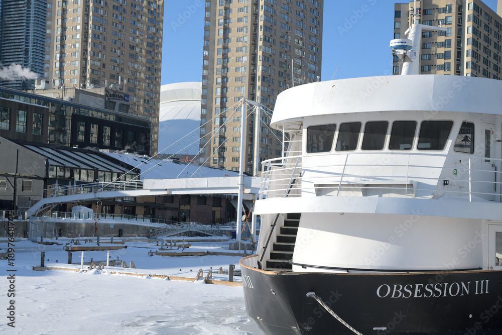 Fototapeta premium looking north west from Harbourfront Centre to The Obsession III, a well-known 78-foot motor yacht that operates as a commercial cruise vessel in the Toronto Harbour