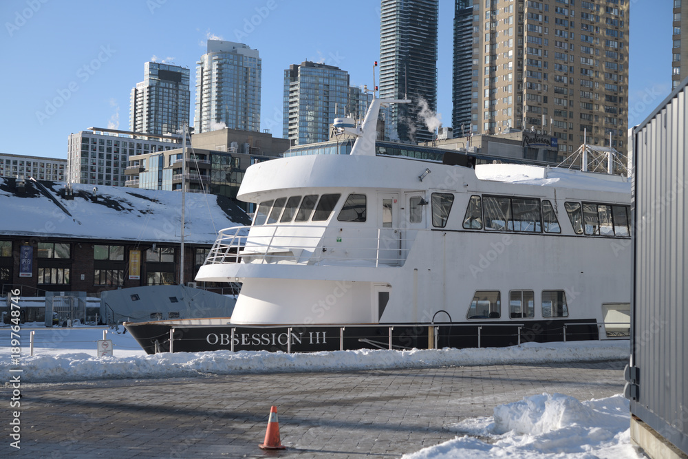 Fototapeta premium looking north west from Harbourfront Centre to The Obsession III, a well-known 78-foot motor yacht that operates as a commercial cruise vessel in the Toronto Harbour