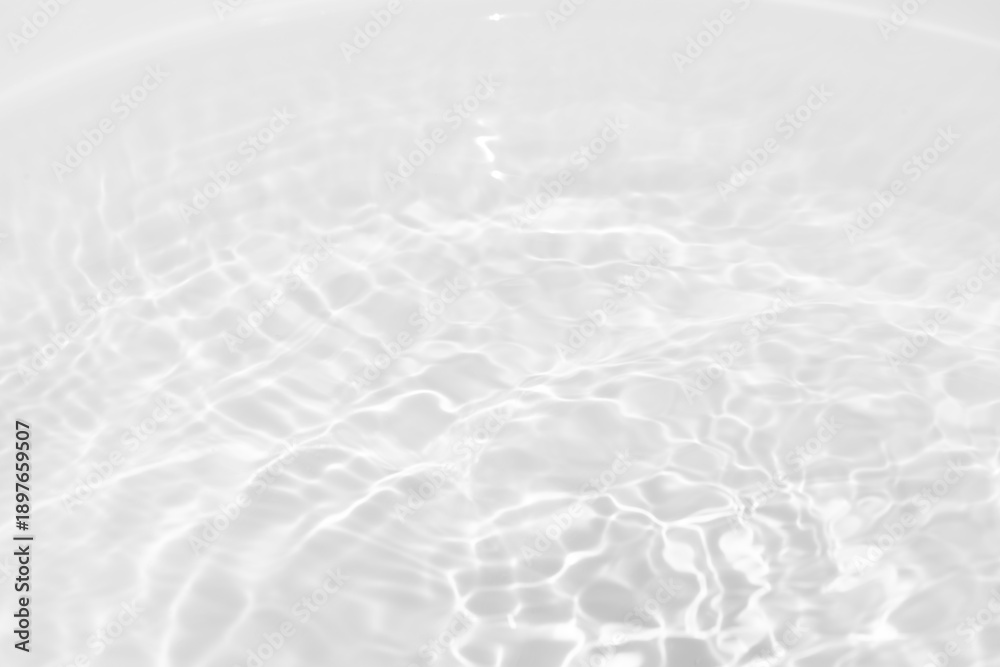 Obraz premium Blue water with ripples on the surface. Defocus blurred transparent blue colored clear calm water surface texture with splashes and bubbles. Water waves with shining pattern texture background.