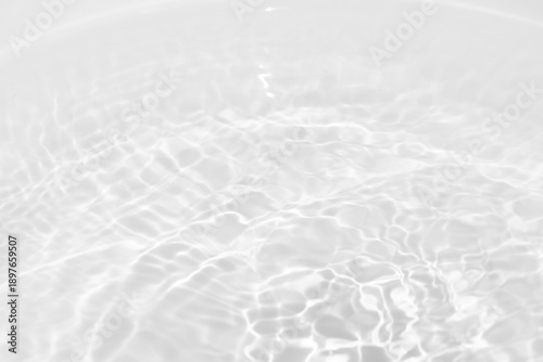 Blue water with ripples on the surface. Defocus blurred transparent blue colored clear calm water surface texture with splashes and bubbles. Water waves with shining pattern texture background.