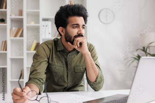 Tired Indian man takes off glasses, suffers from painful sensations, has problems with astigmatism. A man stressed after a long working day at the computer relieves the pain in his eyes.