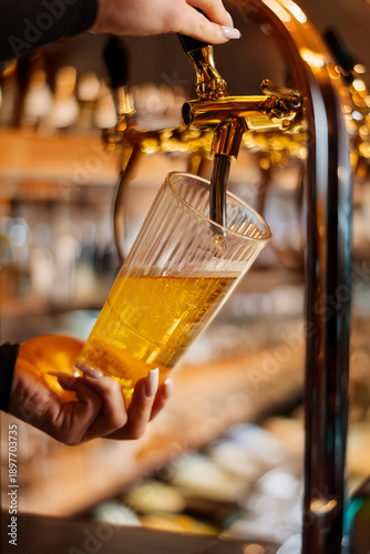Konstfotografi Fresh draft beer being poured from taps into a glass
Golden lager served from a
