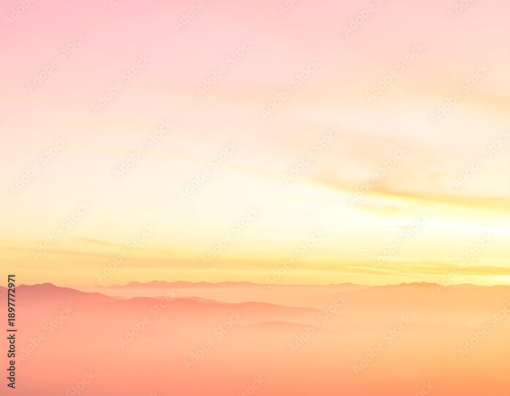 Fototapeta premium A serene, vertical image captures a tranquil dawn over distant mountain ranges shrouded in a delicate, soft mist with a gradient sky