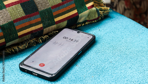 Quadro em tela Voice detection and recording app in mobile phone listening to contestation laying on couch or sofa hidden from view
