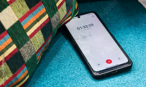 Quadro em tela Voice detection and recording app in mobile phone listening to contestation laying on couch or sofa hidden from view