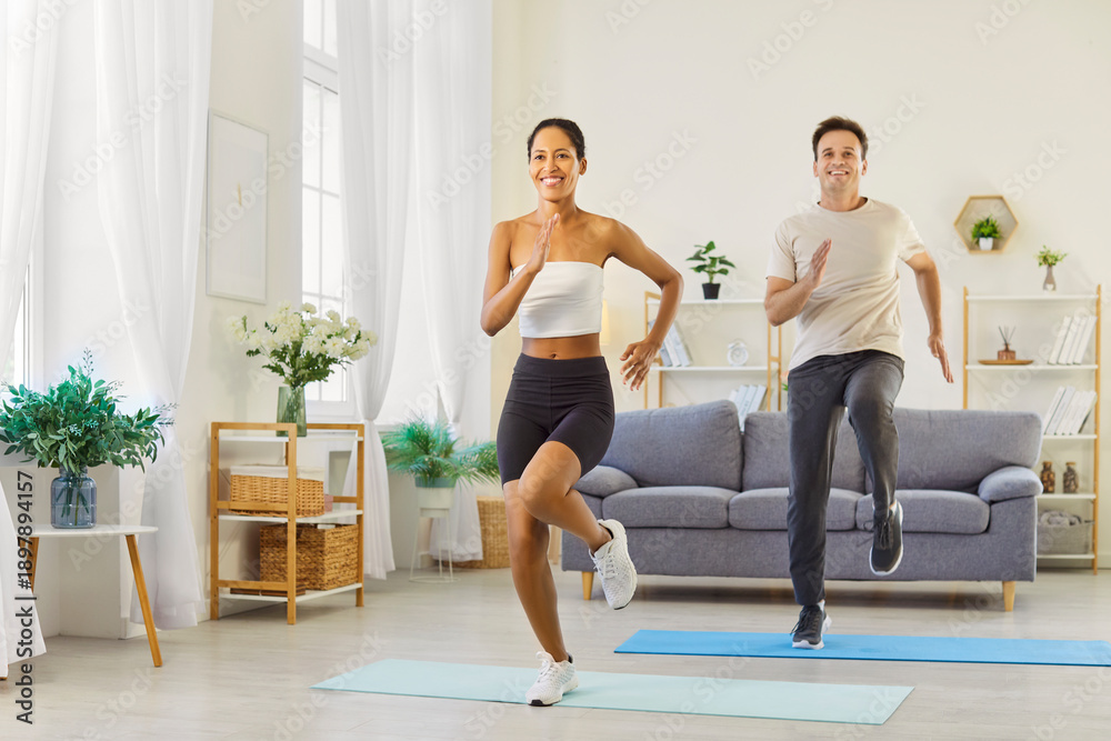 Obraz premium Couple family fitness workout at home exercise. They do high-knee cardio on mats, smiling in sync, building strength and endurance with supportive training. Motivation and health with teamwork.