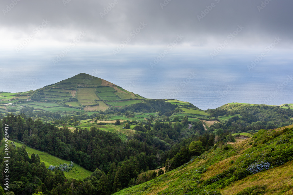 Fototapeta premium Volcanic landscape on San Miguel Island, Azores. View from Sete Cidades and surrounding mountains. Lush greenery, natural scenery in Portugal.
