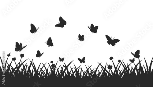 Black butterfly silhouettes flying above fresh spring meadow grass creating a clean seasonal nature background