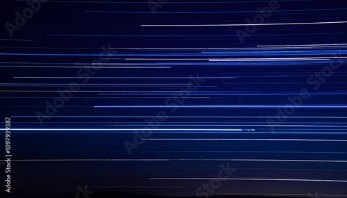 Nighttime long exposure shows streaks of light against a deep blue sky