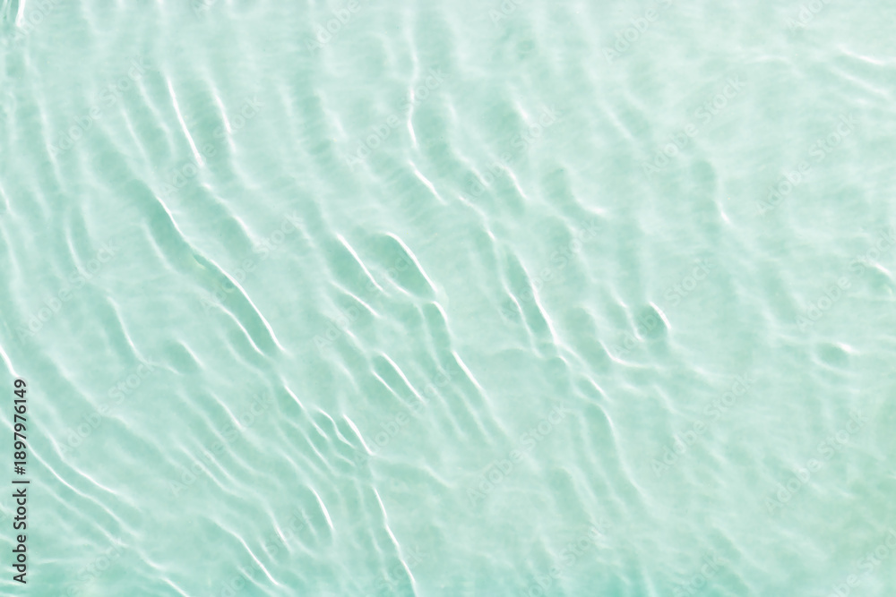 Fototapeta premium Clear water and waves at sunlight, sun flare and bright white reflections on blue, turquoise water surface. Summer vivid gradient color, graphic nature, dynamic aquatic ripples pattern, aesthetic