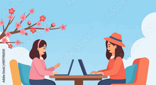 Two women working on laptops outdoors under a blooming tree