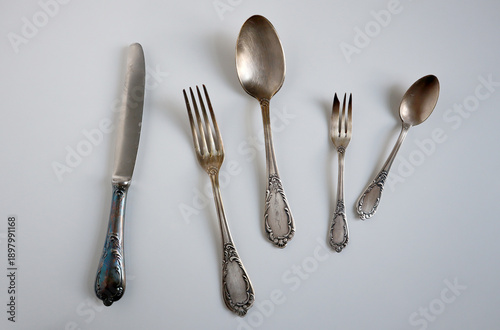 Photos Vintage nickel silver or Melchior cutlery set of knife, forks, spoons on a light grey background