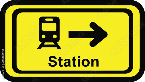 Yellow road sign indicating direction to the nearest train station with a bus icon.