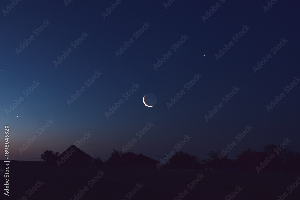 Fototapeta premium Morning old Moon with stars, planets and rural countryside tree silhouettes.