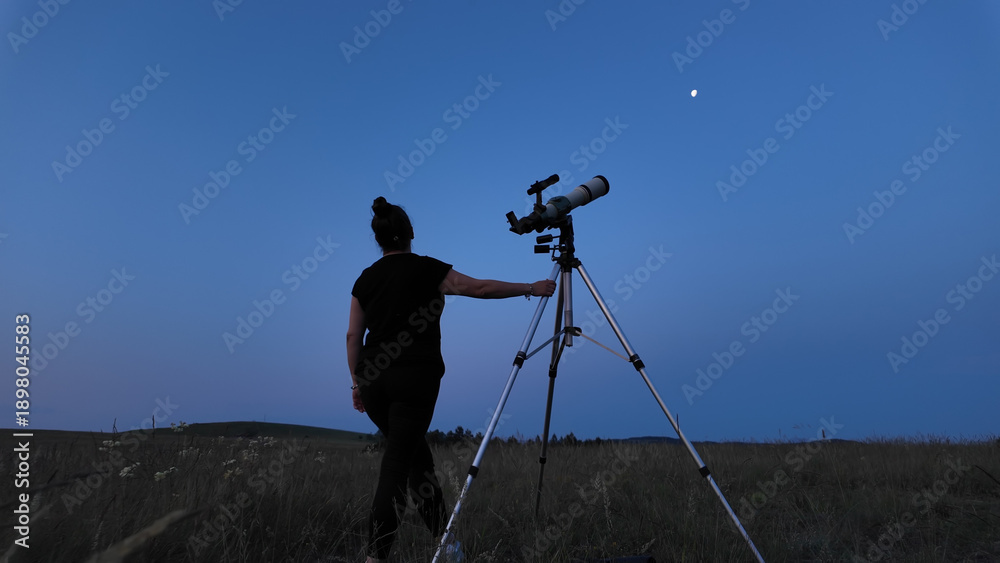 Fototapeta premium Amateur astronomer using telescope for watching stars, Moon, planets and other celestial objects from a field in nature.