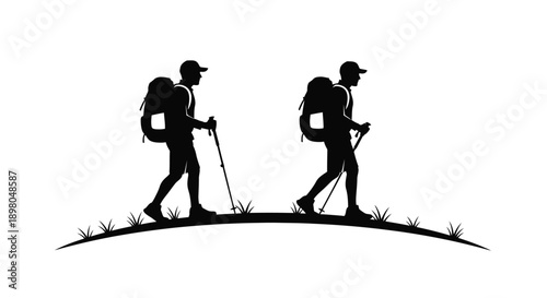 Two hikers with backpacks walk across a grassy hill silhouette