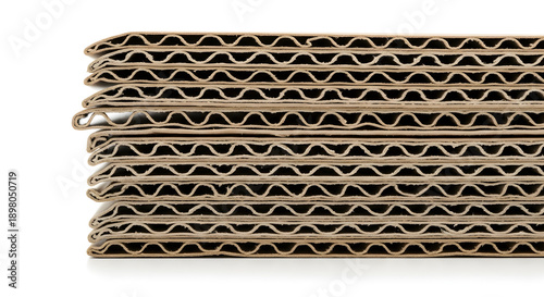 Close-up side view of stacked brown corrugated cardboard sheets showing the fluted layers.
