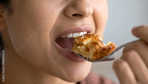 A woman eating a piece of food on a fork