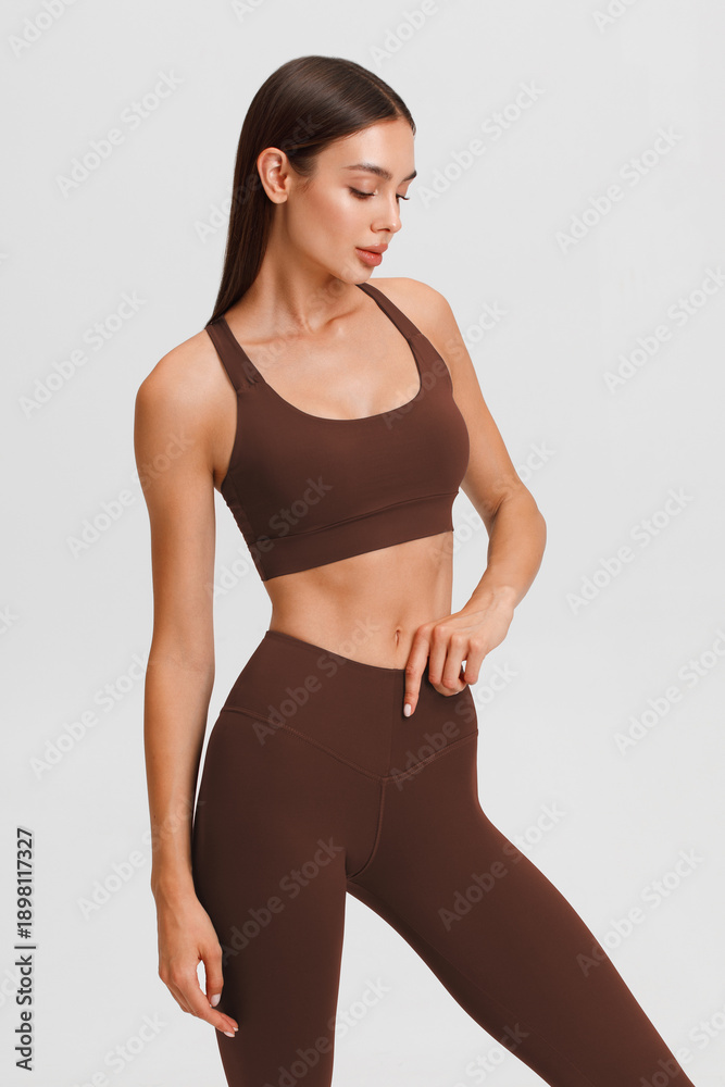 Fototapeta premium Athletic girl on the gray background. Fitness woman
