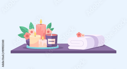 Serene spa setting with lit candles, flowers, and a rolled towel