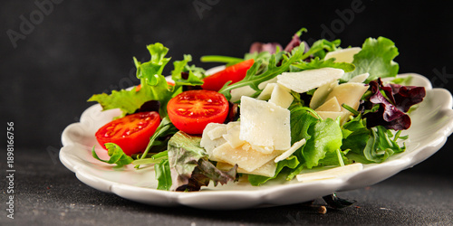 Parmesan cheese vegetable salad tomato, arugula, green leaf lettuce healthy food main course ingredient appetizer fresh tasty gourmet food background on the table rustic food 