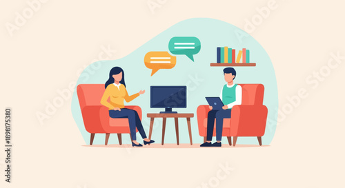 Two people in armchairs conversing near a monitor and bookshelf