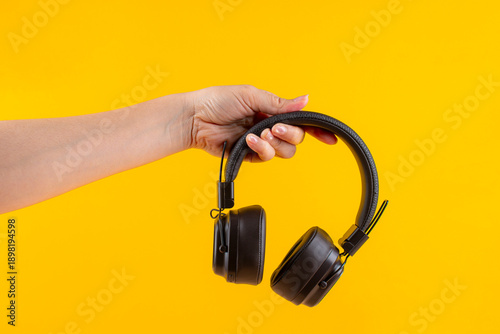 Wallpaper Mural HeadPhones in hand, Headphones isolate on yellow. Wireless headphones in brown. Torontodigital.ca