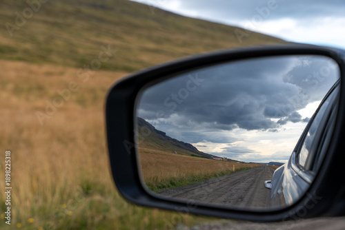 dark clouds reflected in car side mirror 