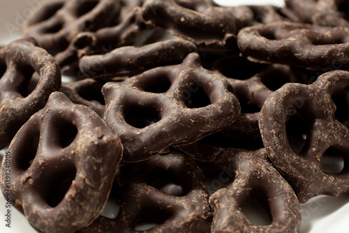 A closeup view of a pile of dairy-free, gluten-free dark chocolate covered pretzels.