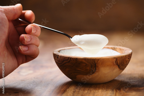 Wallpaper Mural Pov shot of young female hand with full spoon of yogurt sitting at the table Torontodigital.ca