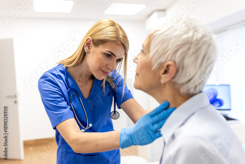 Photos Medical specialist checking senior woman's lymph nodes in clinic office