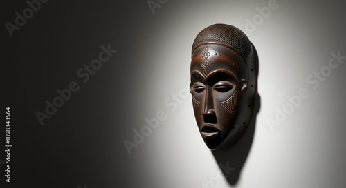 Foto Carved wooden mask detailed features set against a gradient lighttodark wall