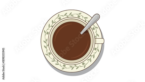 Top-down view of a cup of dark coffee or hot chocolate with a spoon on a decorative saucer.