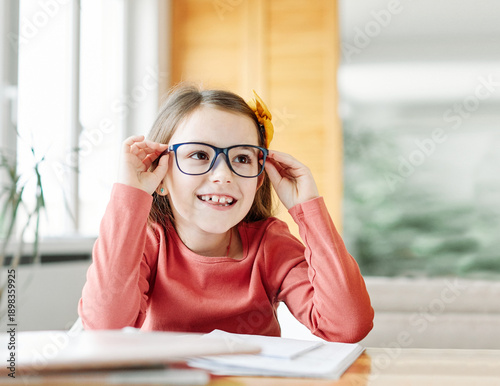 Wallpaper Mural Portrait of a teenage girl doing homework with laptop at home, Concentrated beautiful female white child writing in her notebook. Focused caucasian schoolgirl studying and preparing for exams Torontodigital.ca