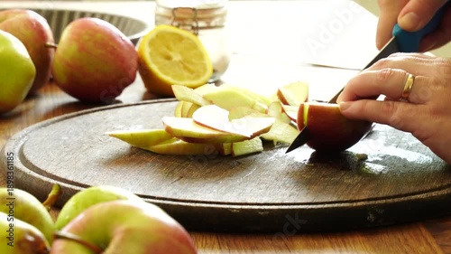 Woman cuts apples and pears for pie

