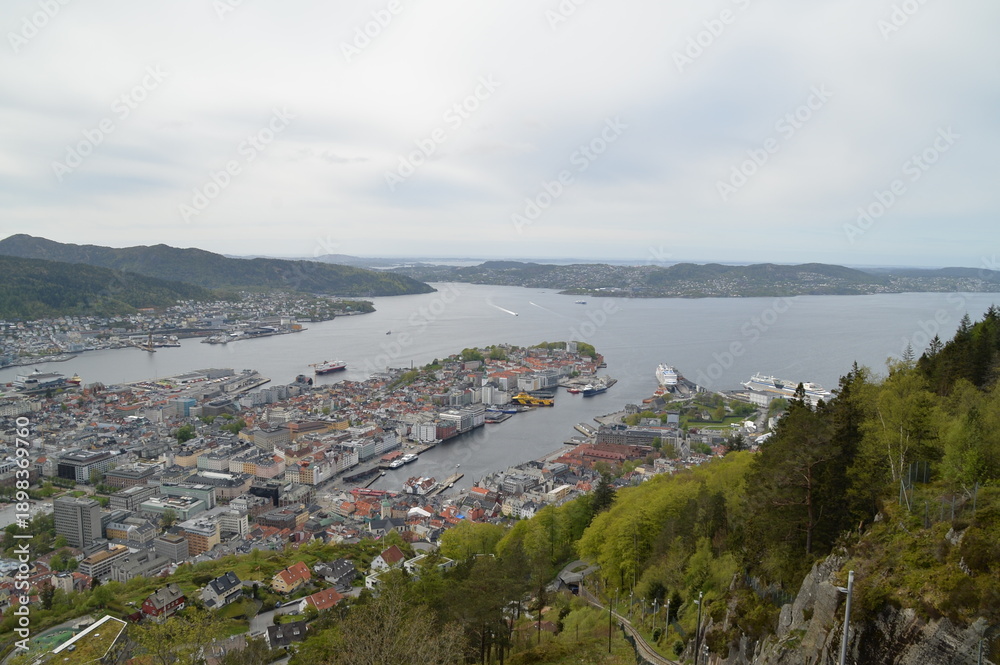 Obraz premium Panoramablick über Bergen in Norwegen mit Hafen, Fjord und umliegenden Bergen. Naturnahe Stadtlandschaft mit maritimem Flair, ideal für Reise, Natur und skandinavische Atmosphäre.
